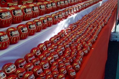 Red daruma dolls displayed at market stall