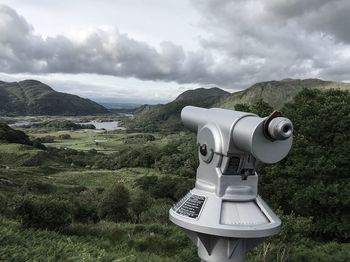 Close-up of coin-operated binoculars against cloudy sky