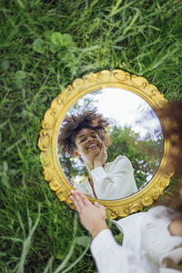 High angle view of woman holding mirror
