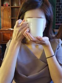 Midsection of woman drinking coffee