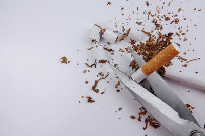 High angle view of cigarette on table against white background