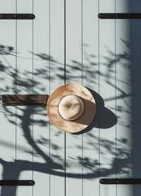 Hat hangin on old wooden door, pastel colored, neutrals.