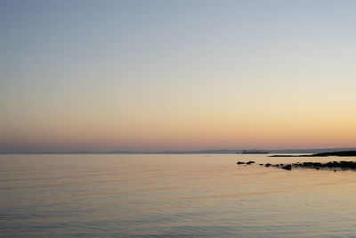 Scenic view of sea against clear sky during sunset