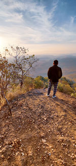 Rear view of man on land against sky