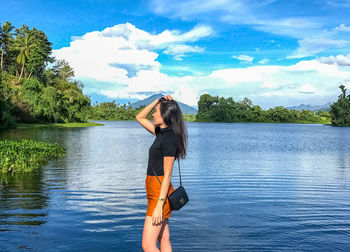 Woman standing in lake against sky