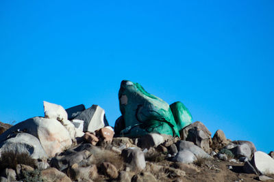 Low angle view of horse in sea against clear blue sky