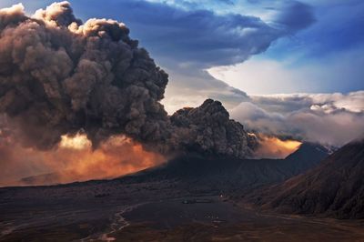 Smoke emitting from volcanic mountain against sky