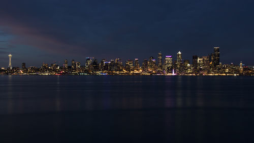 Illuminated buildings against sky at night