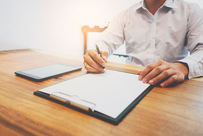 Midsection of man using laptop on table