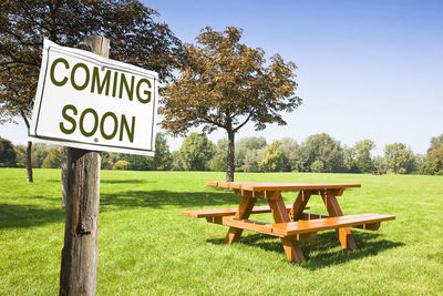 Information sign on field by park bench