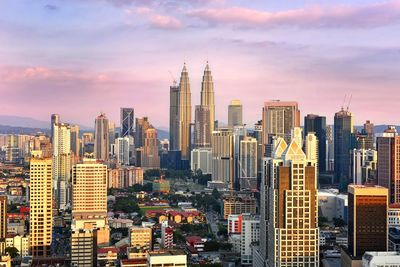 Petronas tower amidst cityscape during sunset