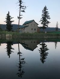 Reflection of building on lake against sky