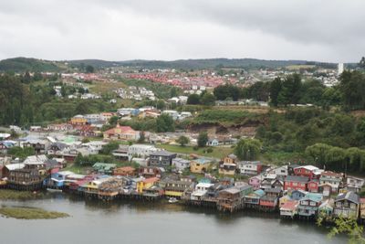 Townscape by river against sky