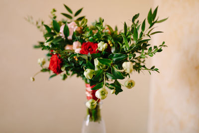 Close-up of flower vase on table against wall