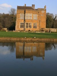 Reflection of building on lake against sky