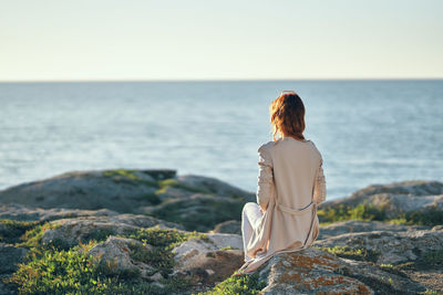 Rear view of woman looking at sea against sky