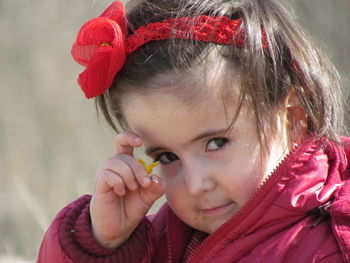 Close-up portrait of girl holding tiny flower