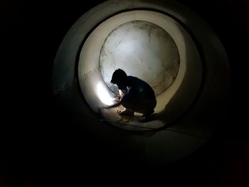 High angle view of silhouette man light painting against black background