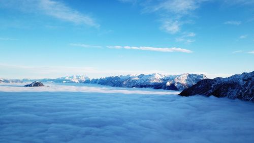 Scenic view of snowcapped mountains against blue sky