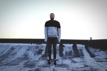 MAN STANDING ON WATER AGAINST SKY