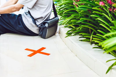 Midsection of man next to cross marking outdoors