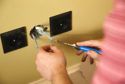 Cropped hand of man repairing equipment