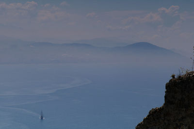 Scenic view of sea and mountains against sky