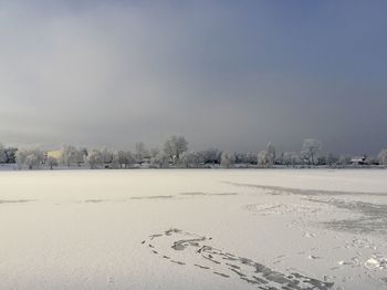 Scenic view of snow covered field against sky