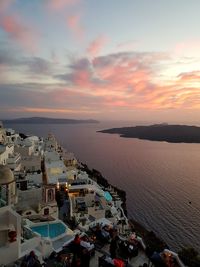 High angle view of sea and buildings against sky during sunset