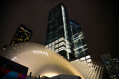 Low angle view of illuminated buildings against sky at night