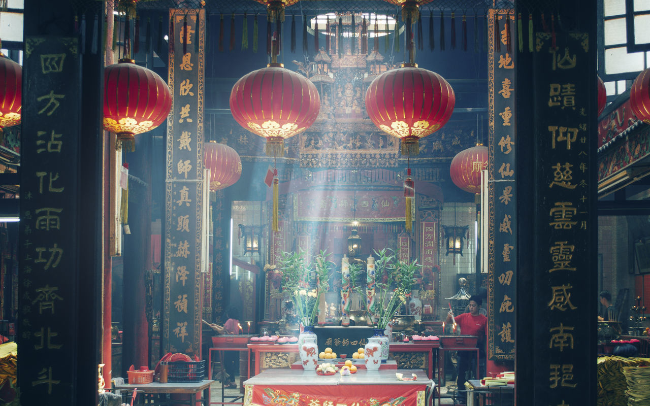 ILLUMINATED LANTERNS HANGING BY BUILDING