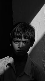 Close-up of boy against wall at home