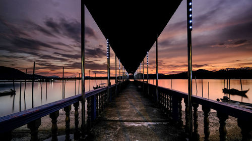 Bridge over sea against sky during sunset