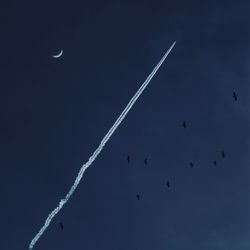 Low angle view of airplane flying against blue sky