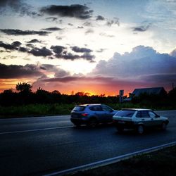 Cars on road at sunset