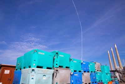 Low angle view of vapor trails against blue sky