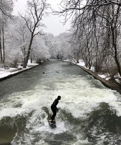 Man on river against sky during winter