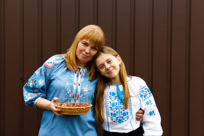 Easter family. mother and daughter holding easter eggs and hugging. looking at camera. ukraine