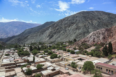 Townscape by mountains against sky