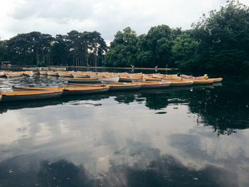 Boats moored in river against sky