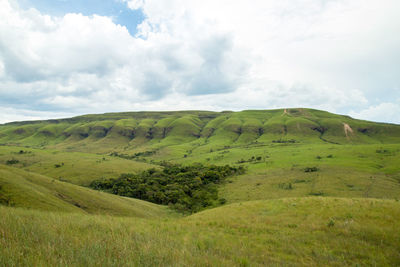 Scenic view of green landscape against sky