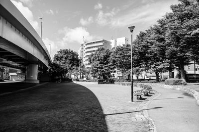 Street amidst trees and buildings against sky