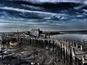 Abandoned built structure on beach against sky