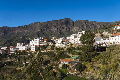 Buildings in town against clear blue sky