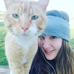 Portrait of smiling young woman with cat