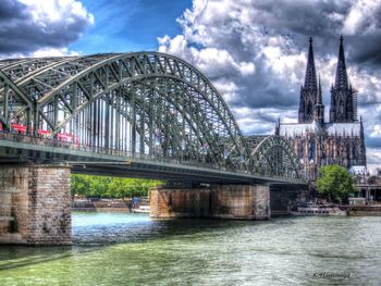 Bridge over river against cloudy sky