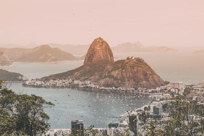 Scenic view of sea and cityscape against clear sky