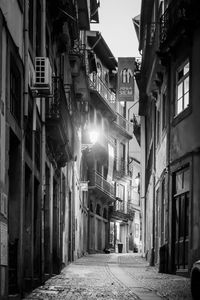 Narrow street amidst buildings in city at night