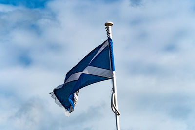 Low angle view of flags against blue sky