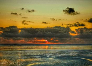 Scenic view of sea against orange sky